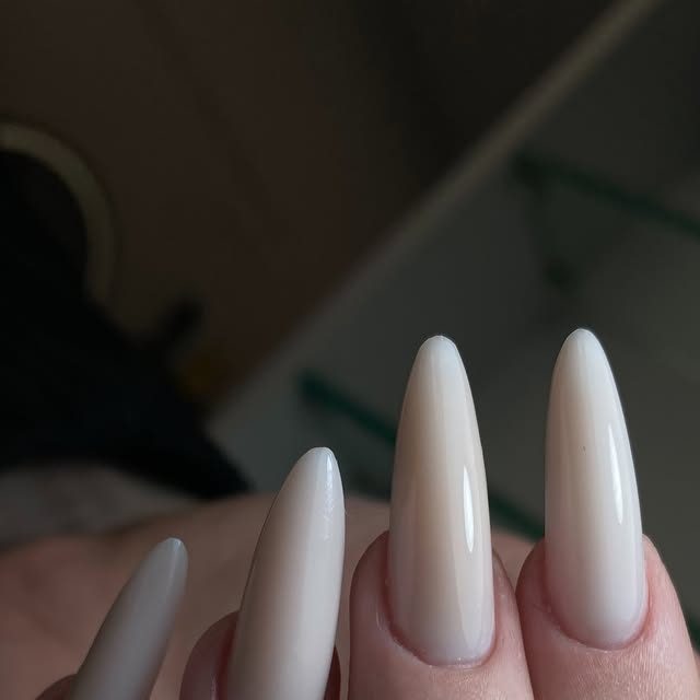 Long almond-shaped nude gel nail extensions by Yuliia